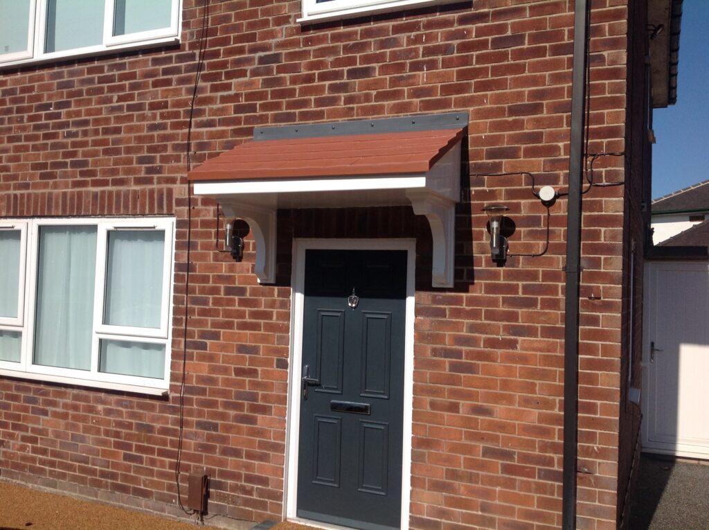 A mono pitch door canopy installed on the front of a house