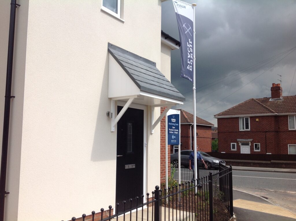 A new build house with a white mono-pitch canopy installed above the front door