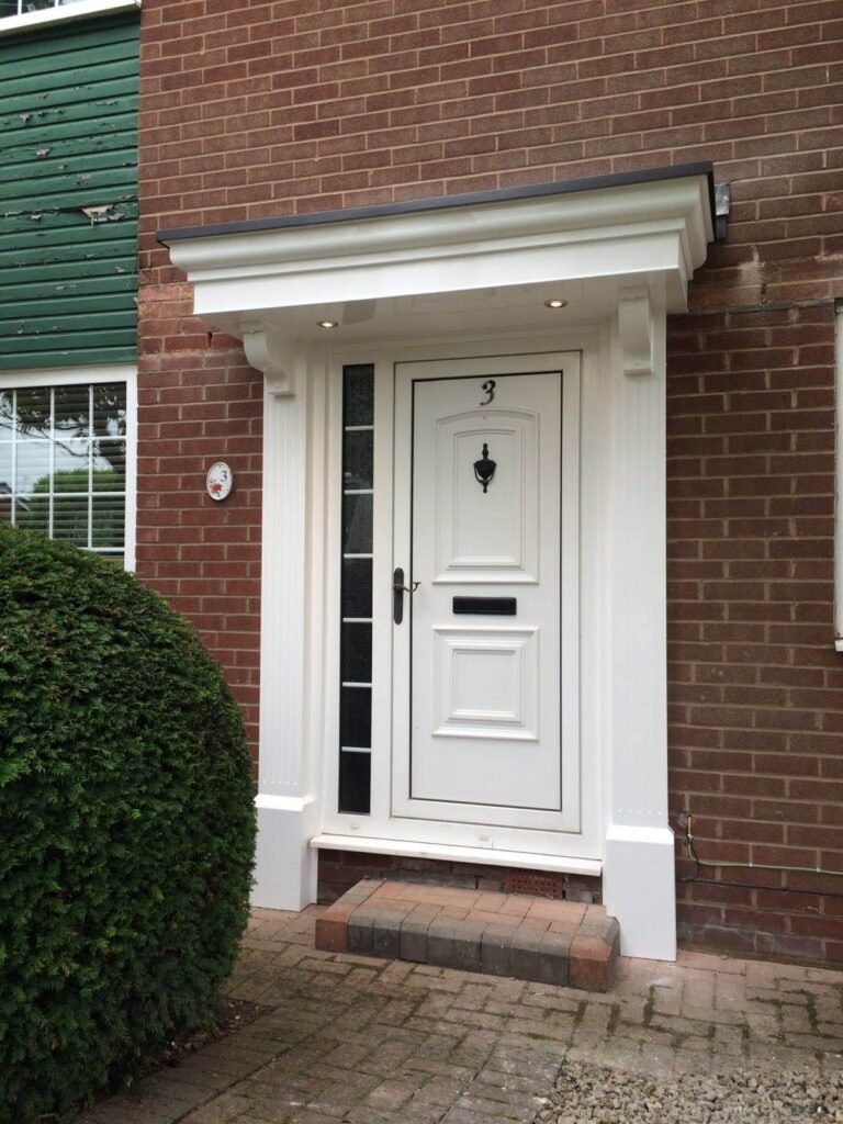 An Anglia door with a fancy flat door canopy fitted above, featuring pillars and corbels