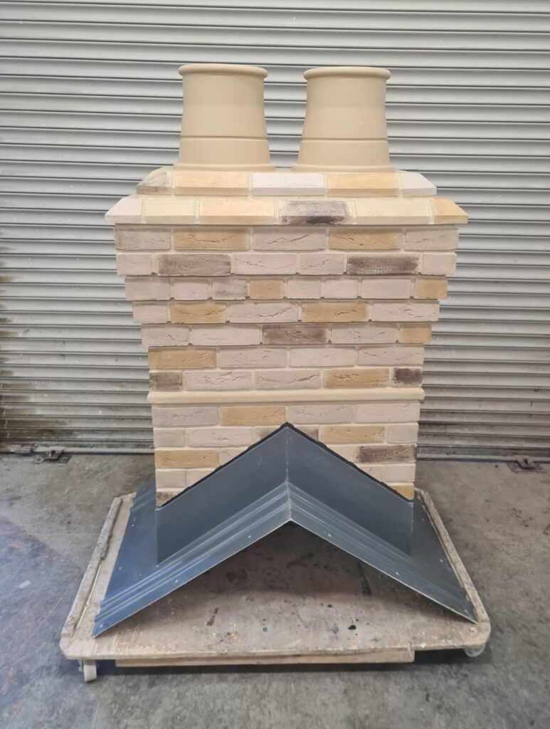 A large light brick-effect two flue chimney made of GRP