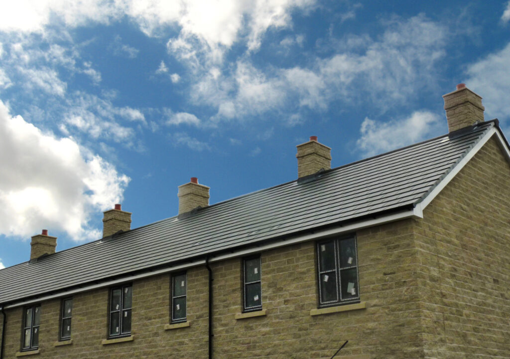 New build terraced houses with stone brick-effect chimneys on the roof